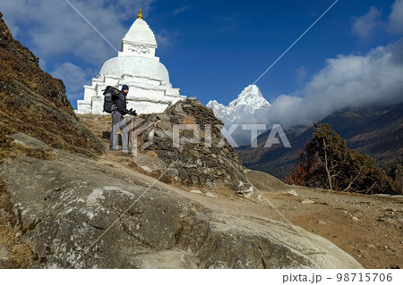 Hiker woman posing with mountains at background Hiker woman posing with mountains at background 98715706