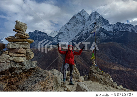 Hiker woman posing with mountains at background Hiker woman posing with mountains at background 98715707