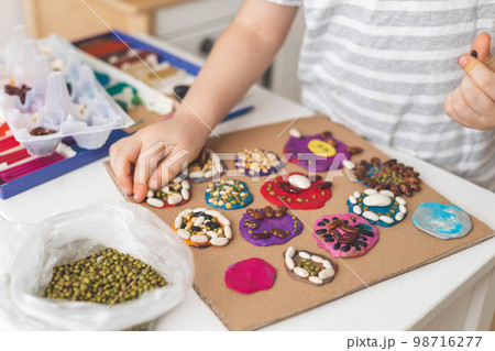 Childish hands decorated plasticine shape natural beans seeds imagination early development closeup Childish hands decorated plasticine shape natural beans seeds imagination early development closeup 98716277