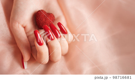 Girl's hands with red manicure and decoratine heart 98716681