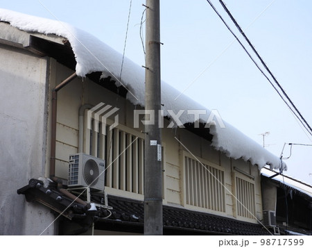 屋根からずれて垂れ下がる雪 98717599
