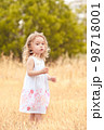 Little baby girl 2-3 year old walking in meadow. Nature. Looking at camera. Childhood. 98718001