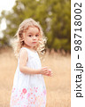 Cute little girl walking in meadow outdoor 98718002