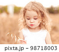 Little funny girl 2-3 year old playing in meadow. Cute child. Childhood. 98718003