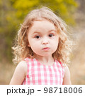 Baby girl 2-3 year old looking at camera over nature background outdoors. Childhood. 98718006