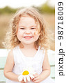 Baby girl 2-3 year old playing the ape outdoors. Looking at camera. Childhood. 98718009