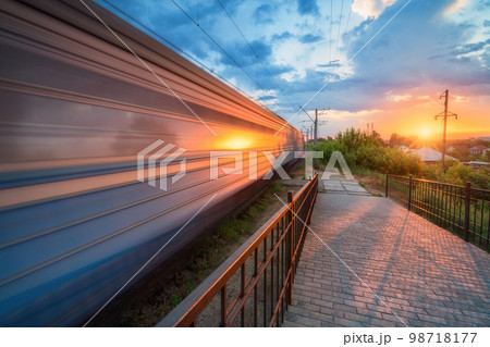 High speed train in motion on the railway station at sunset High speed train in motion on the railway station at sunset 98718177