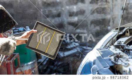Mechanic cleaning dirty car air filter with air blow gun. Mechanic cleaning dirty car air filter with air blow gun. 98718362