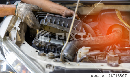 Mechanic is checking and change an air filter. 98718367