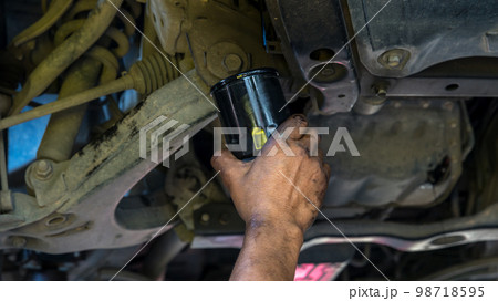 Technician change car oil filter under car. 98718595