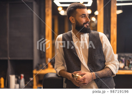 Stylish bearded young man in a barbershop Stylish bearded young man in a barbershop 98719196