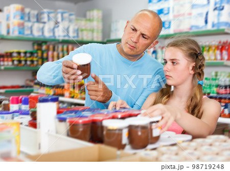 positive father doing shopping with preteen girl in supermarket positive father doing shopping with preteen girl in supermarket 98719248