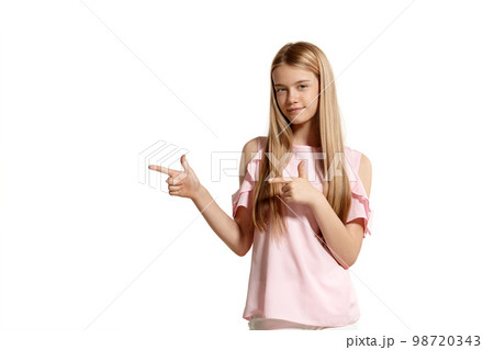 Studio portrait of a beautiful girl blonde teenager in a pink t-shirt posing isolated on white background. Studio portrait of a beautiful girl blonde teenager in a pink t-shirt posing isolated on white background. 98720343