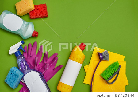 Detergents and cleaning accessories on a green background. Housekeeping concept. Detergents and cleaning accessories on a green background. Housekeeping concept. 98720344