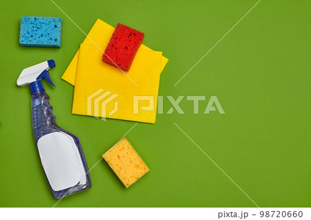 Detergents and cleaning accessories on a green background. Housekeeping concept. Detergents and cleaning accessories on a green background. Housekeeping concept. 98720660