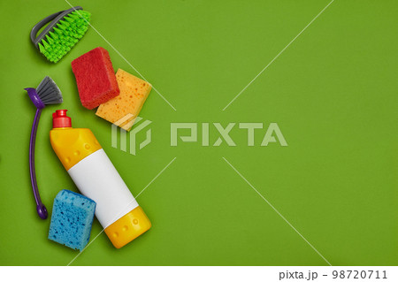 Detergents and cleaning accessories on a green background. Housekeeping concept. 98720711