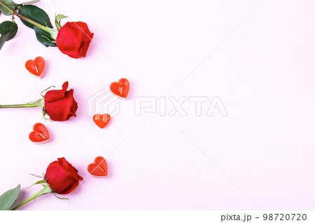 Romantic background with space for text. Red roses and candles in the shape of hearts. Valentine's day concept. Flat lay 98720720