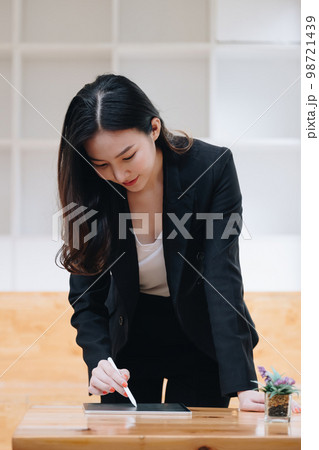 Businesswoman using a calculator application on tablet to audit the company's budget. Tax information is calculated by accountants 98721439