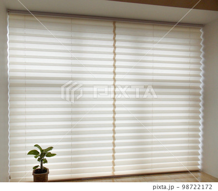 Pleated blinds XL, beige color, with 50mm fold closeup in the window opening in the interior. Home blinds - modern bottom up privacy shades on apartment windows.  98722172