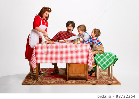 Noisy lovely family morning. Beautiful woman serving pie to her husband and sons sitting at kitchen table 98722254