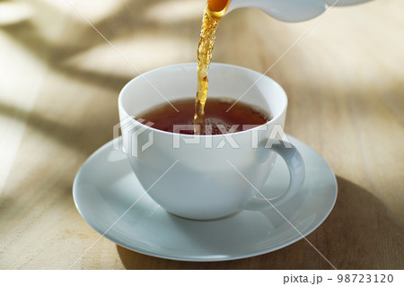 爽やかな陽ざしを受けて紅茶を注ぐ 爽やかな陽ざしを受けて紅茶を注ぐ 98723120
