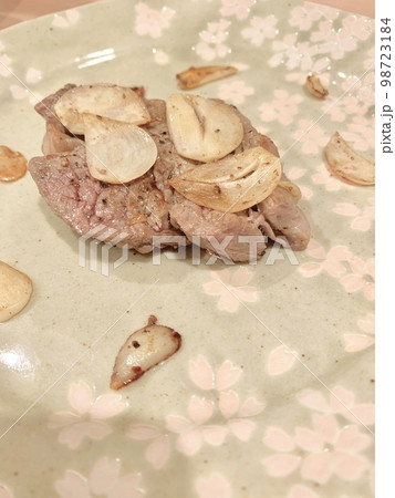 皿に盛られたステーキ肉とニンニク　写真素材 98723184