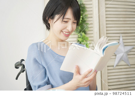 家で読書する車椅子に乗った障がい者女性 98724511