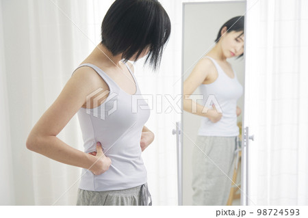 鏡で体型をチェックする女性 鏡で体型をチェックする女性 98724593
