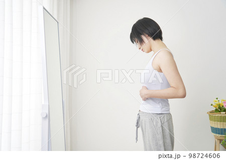 鏡で体型をチェックする女性 鏡で体型をチェックする女性 98724606