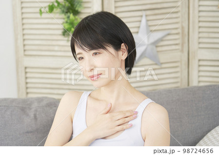 家で胸元のマッサージをする女性 98724656