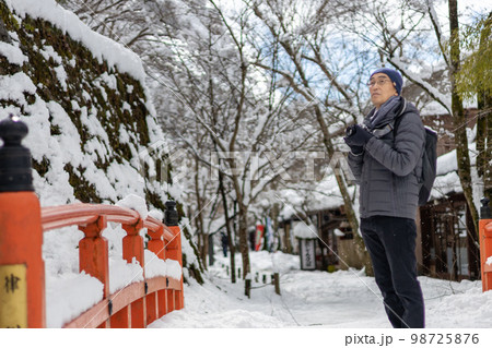 冬の大雪の日、カメラを持って京都大原に旅行にきた一人の中高年男性 98725876