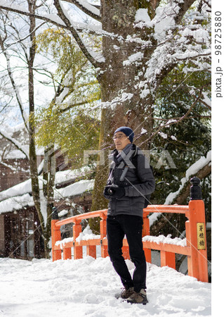 冬の大雪の日、カメラを持って京都大原に旅行にきた一人の中高年男性 冬の大雪の日、カメラを持って京都大原に旅行にきた一人の中高年男性 98725880