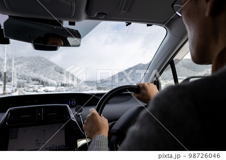 雪が積もっている道路を運転している自動車の運転席と外の冬景色 雪が積もっている道路を運転している自動車の運転席と外の冬景色 98726046