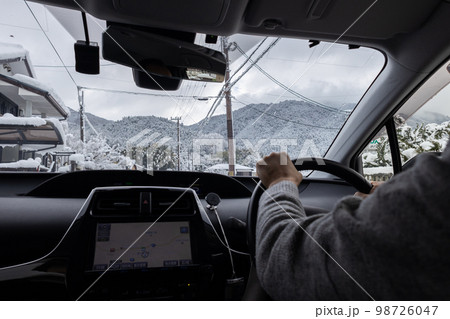 雪が積もっている道路を運転している自動車の運転席と外の冬景色 98726047