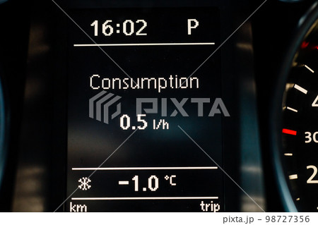 Screen on dashboard of car shows fuel consumption at idle and air temperature outside 98727356