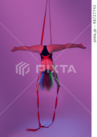 Beautiful girl in a black swimsuit is performing an acrobatic elements in studio. Beautiful girl in a black swimsuit is performing an acrobatic elements in studio. 98727742