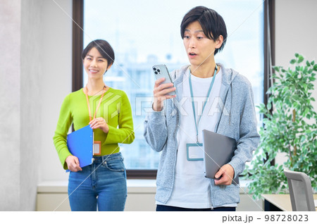 オフィスでスマホを操作する私服の若いエンジニア 98728023