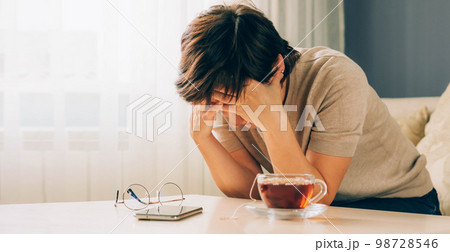 Depressed adult woman covers her face with her hands, cries, feels despair, grief, bad news 98728546