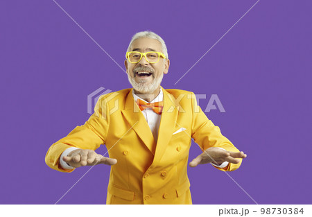 Funny senior man in suit on violet studio background Funny senior man in suit on violet studio background 98730384