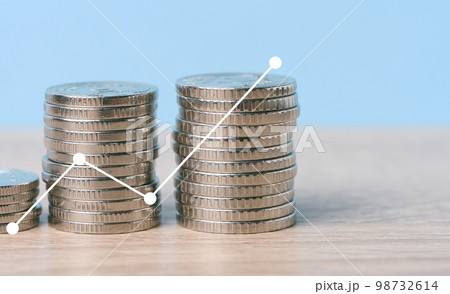 A stack of metallic coins and a chart with growing rates. High income in business, price increase, profit analysis A stack of metallic coins and a chart with growing rates. High income in business, price increase, profit analysis 98732614