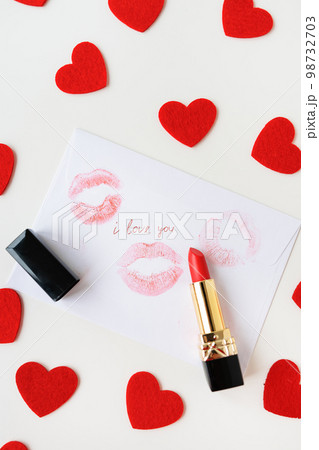 The inscription I love you on a white envelope with a print of lips with red lipstick on a background of small red hearts. The concept of St. Valentine's Day. The inscription I love you on a white envelope with a print of lips with red lipstick on a background of small red hearts. The concept of St. Valentine's Day. 98732703