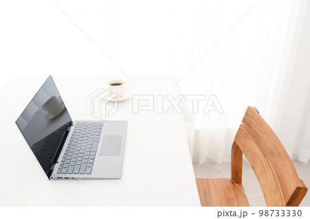 白い机の上にあるノートパソコンとコーヒーカップ(キーボードピント) 白い机の上にあるノートパソコンとコーヒーカップ(キーボードピント) 98733330