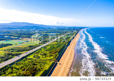 早朝の千里浜なぎさドライブウェイ、のと里山海道（背景は金沢市方向） 98734324