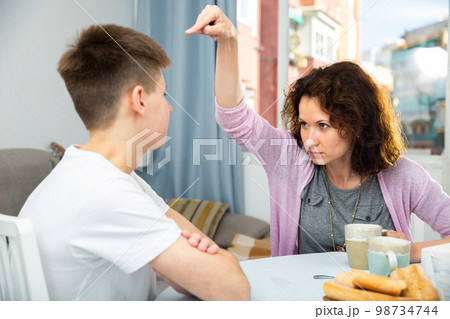 Worried mother talking to son Worried mother talking to son 98734744