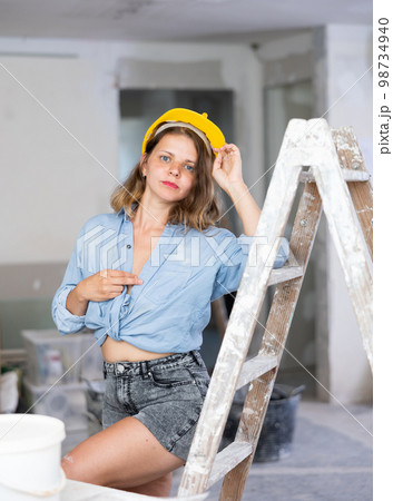 Tempting woman in revealing attire posing in construction site Tempting woman in revealing attire posing in construction site 98734940