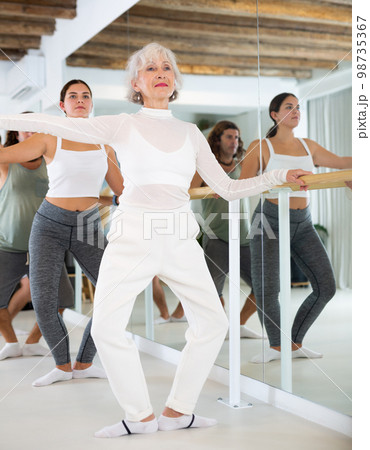 Elderly woman doing ballet at barre 98735367