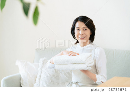 洗濯物を畳むミドル女性 98735671