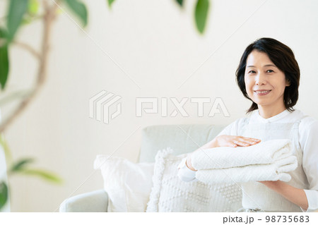洗濯物を畳むミドル女性 98735683