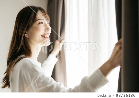 カーテンを開ける女性・起床イメージ 98736136