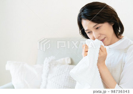 洗ったタオルの匂いを確認する女性 洗ったタオルの匂いを確認する女性 98736343